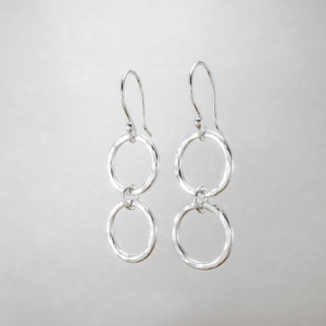These Connected Circles Silver Earrings, feature two hammered silver circles joined together by a smaller central circle, feature a modern design and meticulous craftsmanship.
