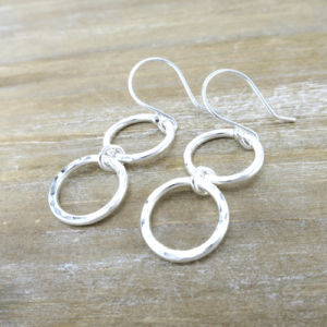 These Connected Circles Silver Earrings, feature two hammered silver circles joined together by a smaller central circle, feature a modern design and meticulous craftsmanship.
