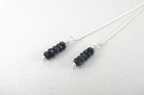 Long and dangly silver threader earrings with a stack of sapphires