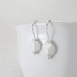 Small sterling silver circle earrings featuring a chick crosshatch pattern and comfortable argentium silver ear wires