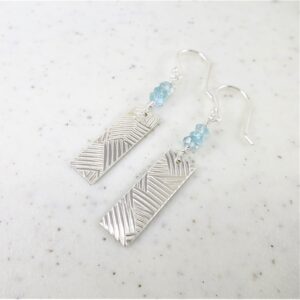 Sterling silver earrings featuring aquamarine beads above dangling patterned silver rectangles.