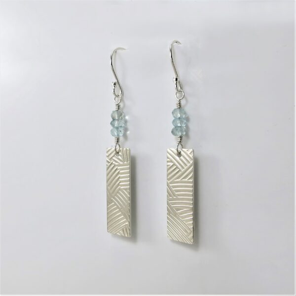 Sterling silver earrings featuring aquamarine beads above dangling patterned silver rectangles.