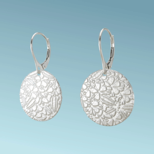 These Dragonfly Whispers silver disc earrings, with an intricately patterned surface featuring hidden dragonflies, will add whimsical charm to your day.