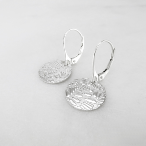 Silver Shimmer: Small Disc Earrings, displaying their intricate textured surface and radiant silver hue.