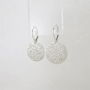 These Dragonfly Whispers silver disc earrings, with an intricately patterned surface featuring hidden dragonflies, will add whimsical charm to your day.