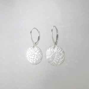 Silver Shimmer: Small Disc Earrings, displaying their intricate textured surface and radiant silver hue.