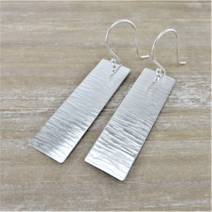 A pair of rectangular earrings with a horizontal line pattern, known as "Line Elegance Rectangle Earrings." The design is simple yet refined, highlighting the sleek lines and modern aesthetic.